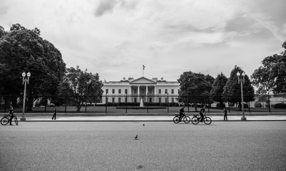 The White House, with bicyclists appearing before it