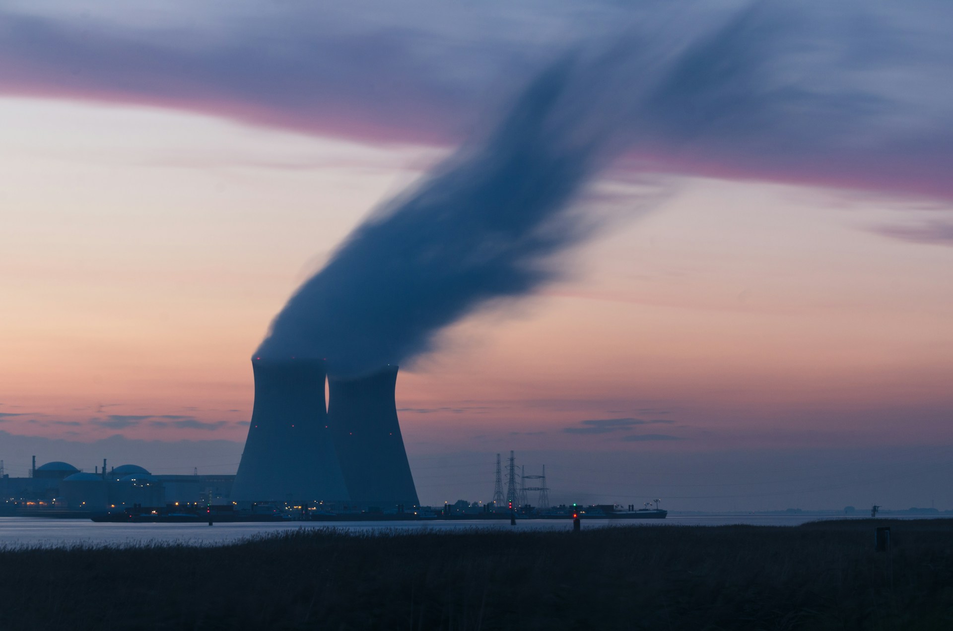 The cooling towers of a nuclear power plant, venting steam into the sunset - photo courtesy Frédéric Paulussen