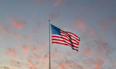 USA flag flying under partly cloudy sky at sunset