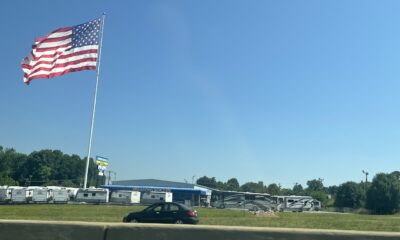 American flag flying over a camper park next to a busy highway