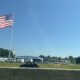 American flag flying over a camper park next to a busy highway