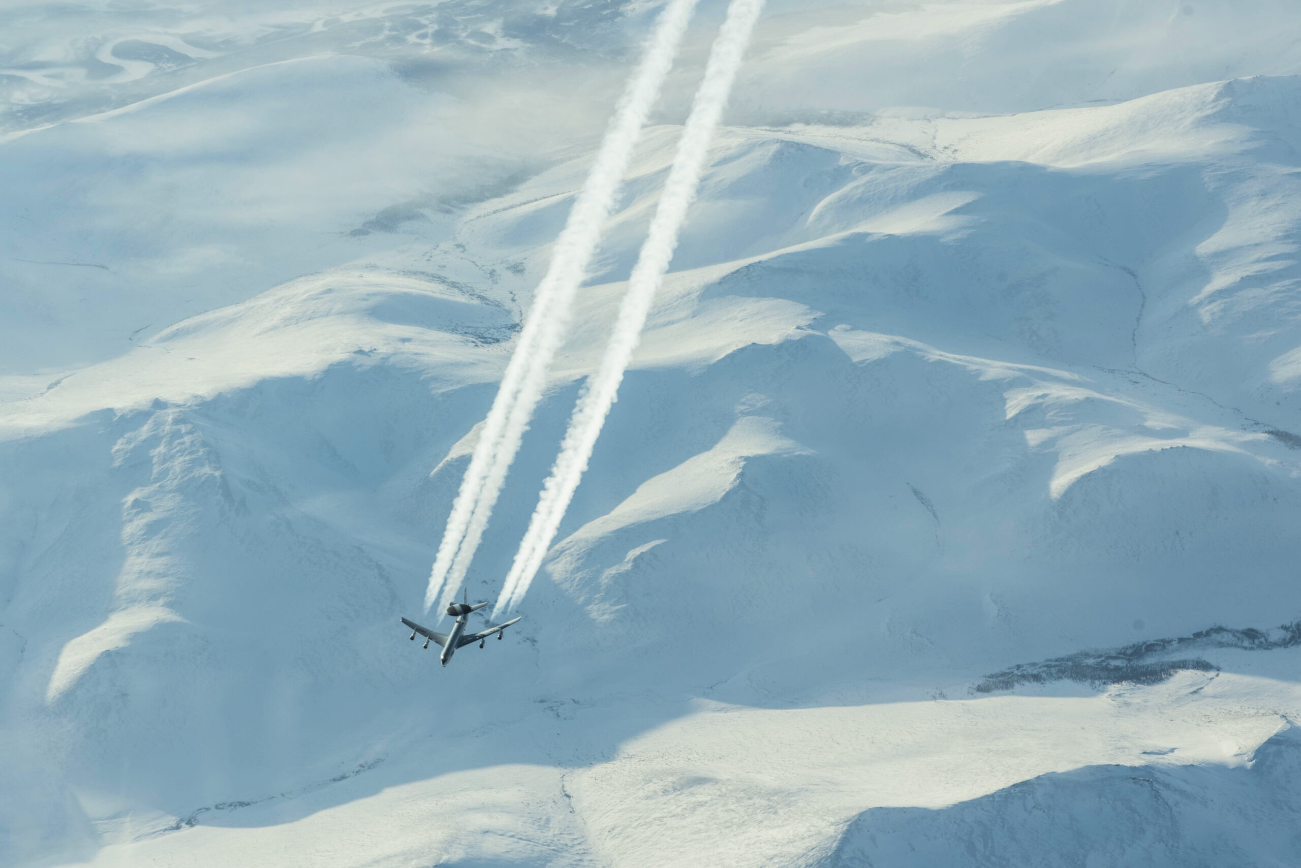 The High Arctic, with an E-3 Sentry (the AWACS platform) overflying some mountains