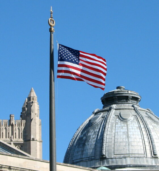 The American Flag flies from the flagpole in Hewitt Quadrangle at Yale University. Buildings shown include the Yale Commons (left foreground), the dome of Theodore Dwight Woolsey Memorial Hall (wherein are inscribed the names of every Yale graduate who ever fell in battle, including President Franklin D. Roosevelt in the WWII memorial section), and the top of Sterling Tower (background, across the intersection of College, Grove, and Prospect Streets). Note: Sheffield-Sterling-Strathcona Hall (abbreviated SSS) is the headquarters of the School of Engineering.