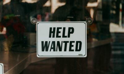 Help Wanted sign outside a retail bar or store - by Nathan Dumlao on Unsplash