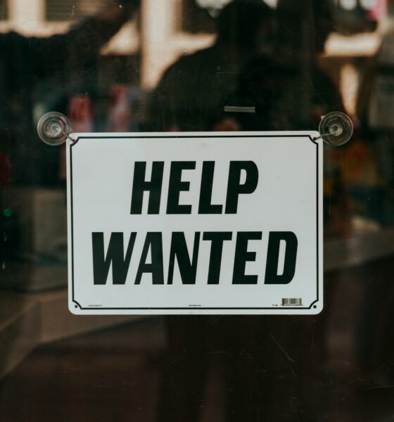 Help Wanted sign outside a retail bar or store - by Nathan Dumlao on Unsplash