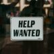 Help Wanted sign outside a retail bar or store - by Nathan Dumlao on Unsplash