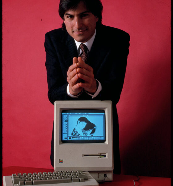 Steve Jobs, founder of Apple Computer, shown with his most famous invention, the first Apple Macintosh