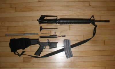 An Armalite AR-15 stripped down, showing receiver, clip, firing pin, barrel, etc.