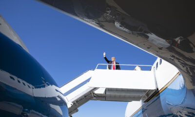 President Trump at the top of the boarding ramp leading into one of his Air Force One planes