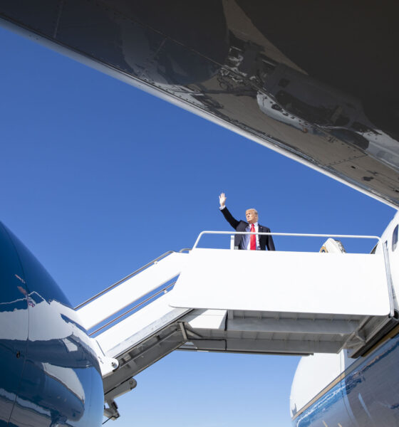 President Trump at the top of the boarding ramp leading into one of his Air Force One planes