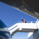 President Trump at the top of the boarding ramp leading into one of his Air Force One planes