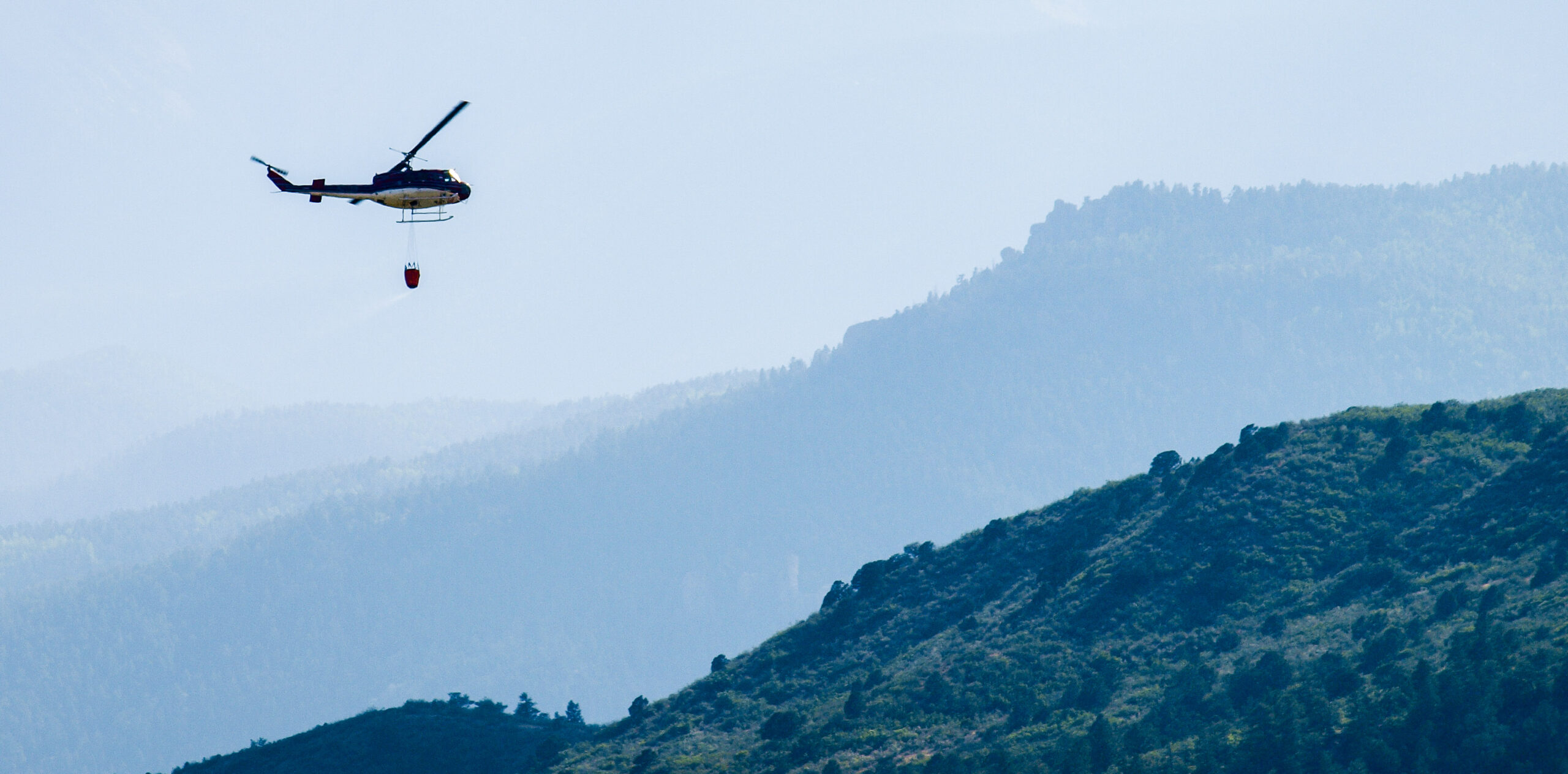A helicopter prepares to drop water onto the Waldo Canyon Fire in Colorado Springs, Colorado in 2012