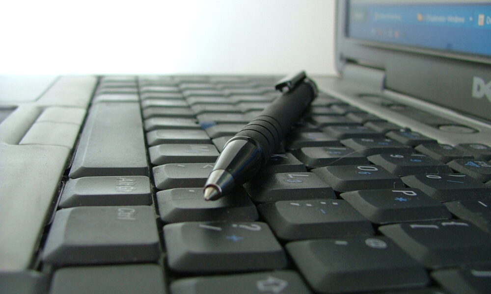 Keyboard with pen lying across it